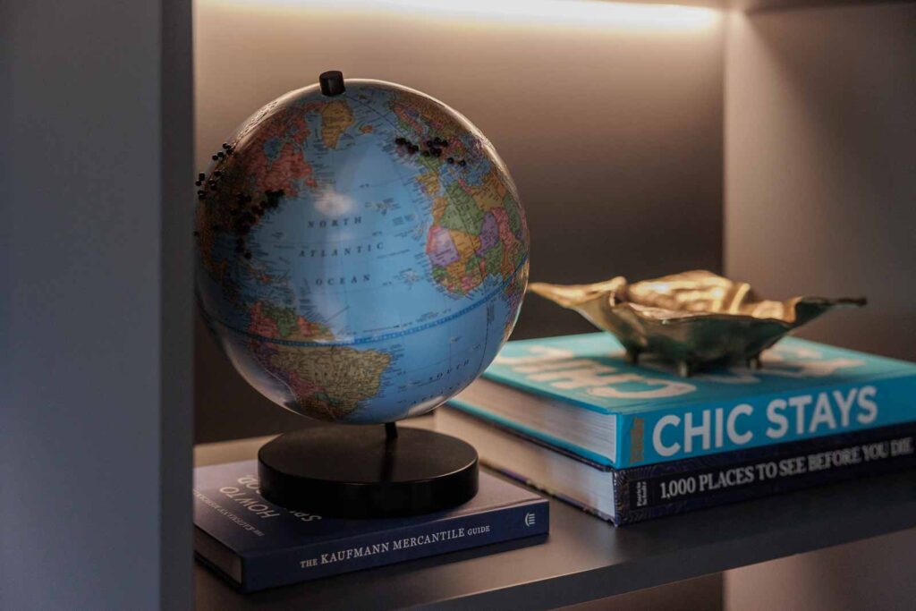 Office detail shot of globe and books on shelf in moody space