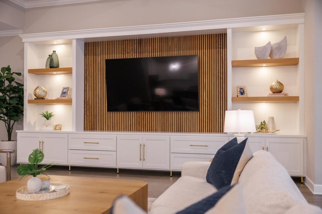 Living room detail with TV built-in with white cabinets and fluted wood backing